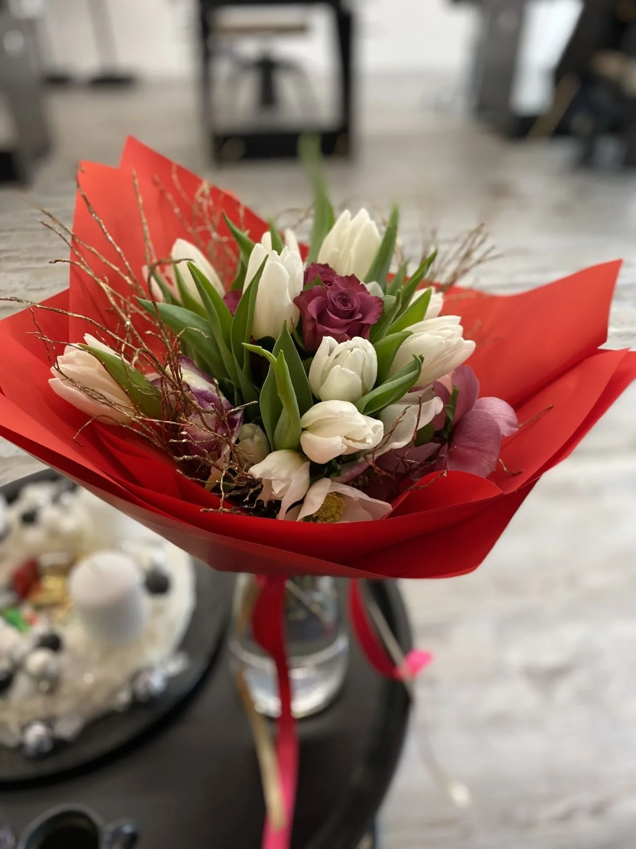 Kytice bílých tulipánů v červeném papíře